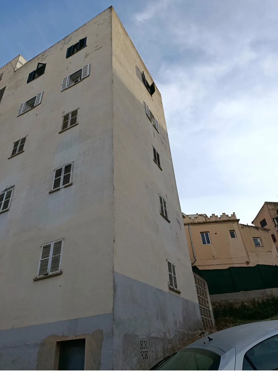 Edificio de comunidad en Mallorca con bajantes perimetrales y canalones que necesitan mantenimiento periódico para evitar filtraciones