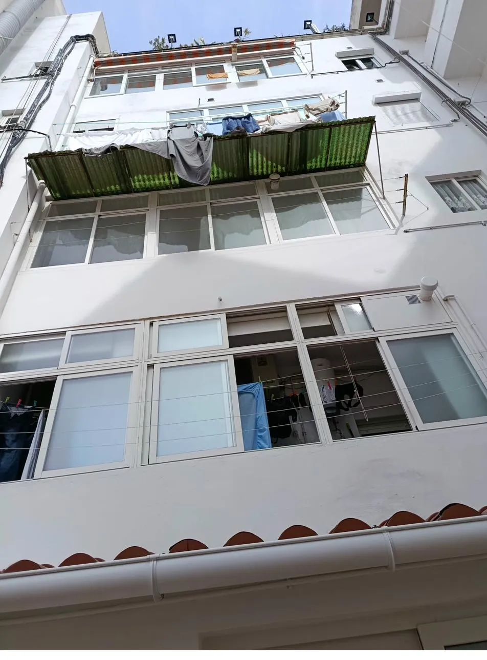 Misma fachada después de la rehabilitación integral: saneada, impermeabilizada y pintada en acabado blanco